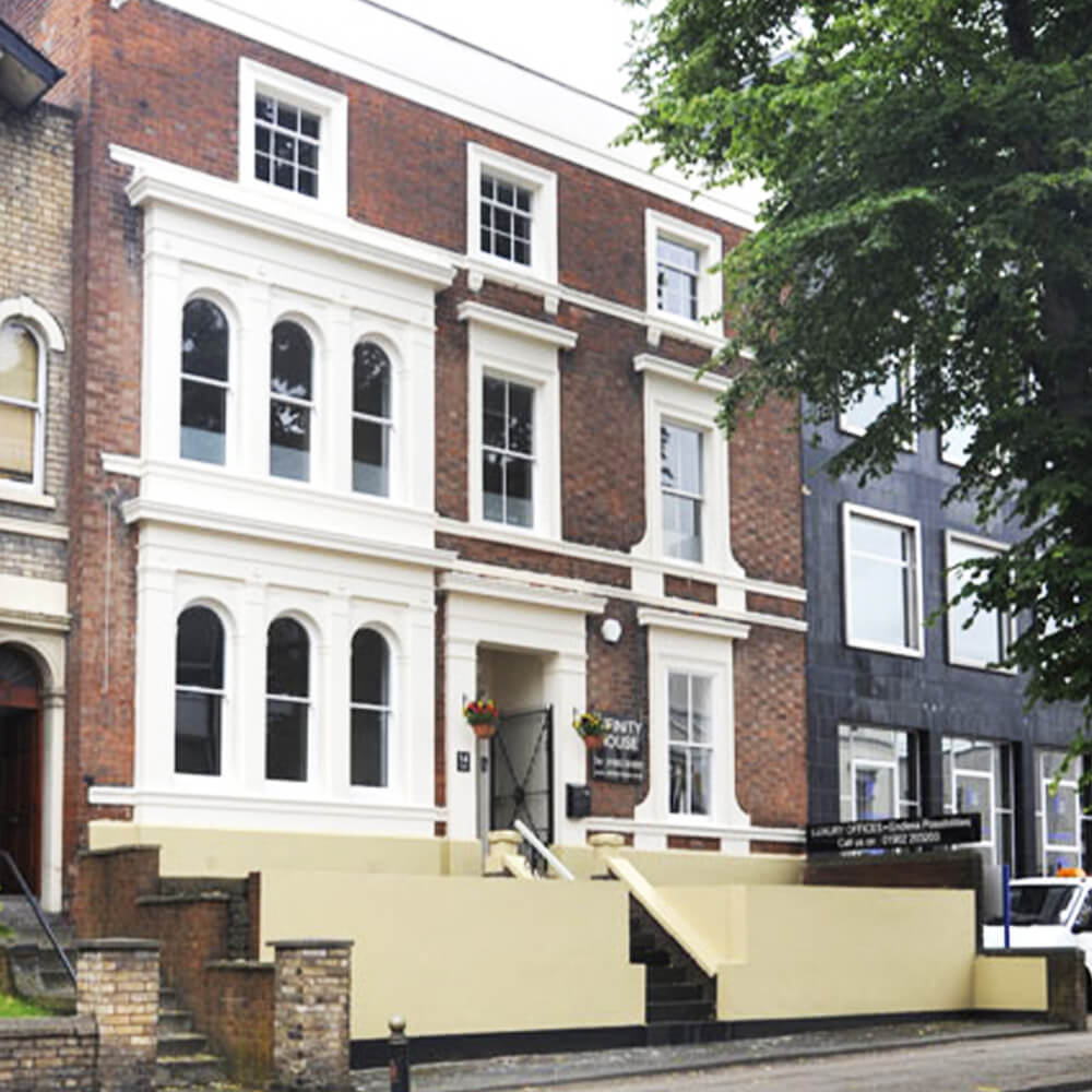 A building with three floors and lots of white windows - Inner Oak Therapy